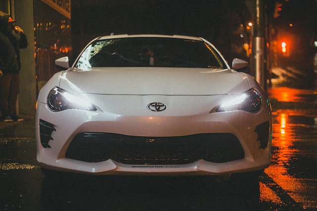 white toyota car driving down the street at night in dublin ca