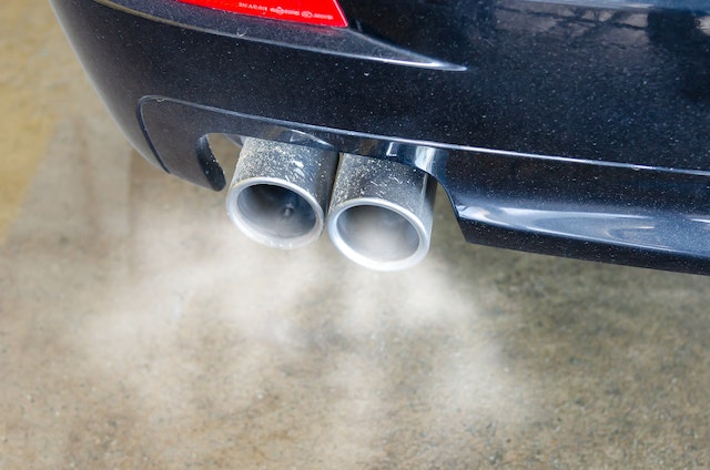 Car exhaust coming out of a tailpipe of a blue car