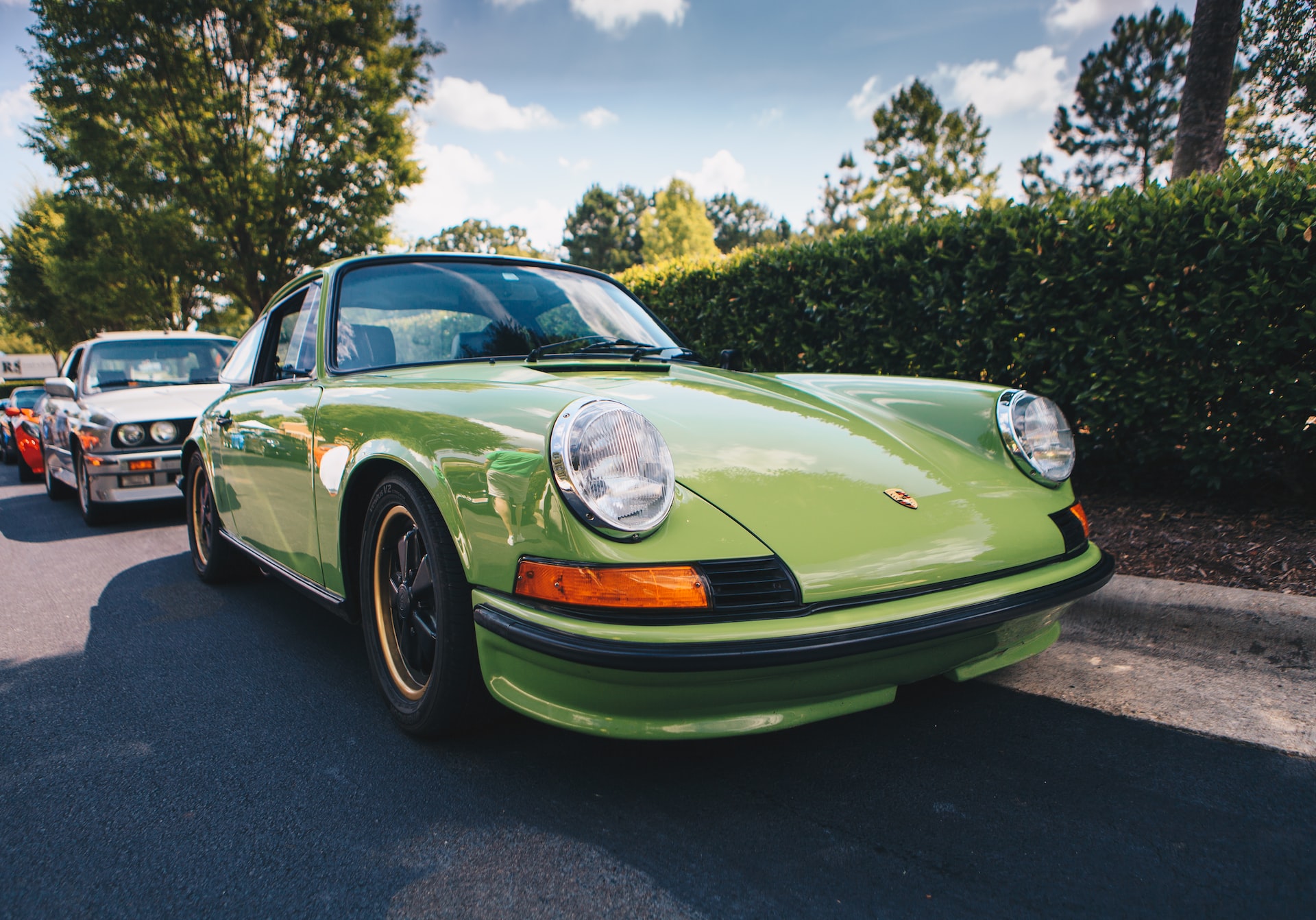 green classic porsche 911 parked on the street